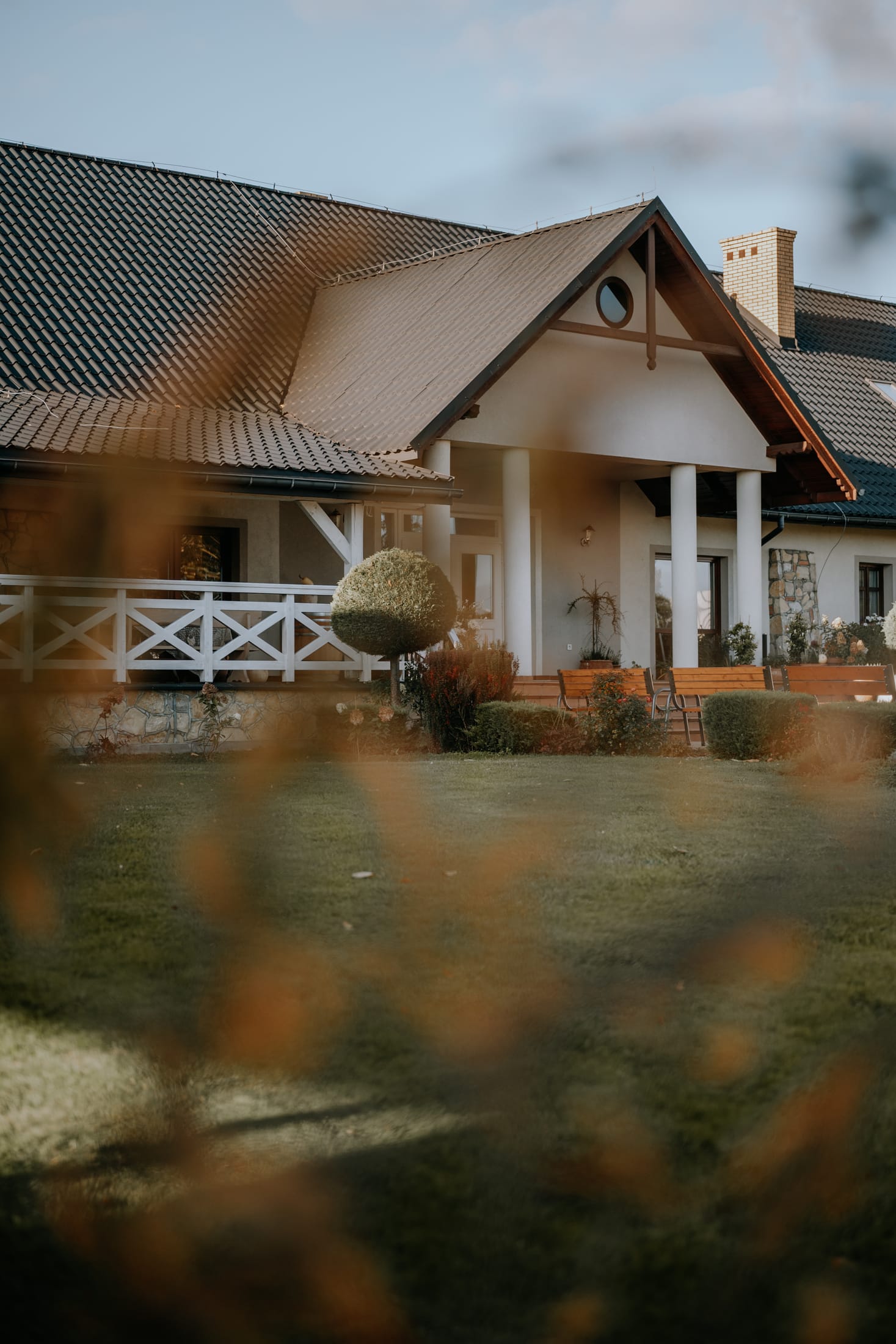 Dwór o złotej godzinie, widok przez ogród z przodu budynku